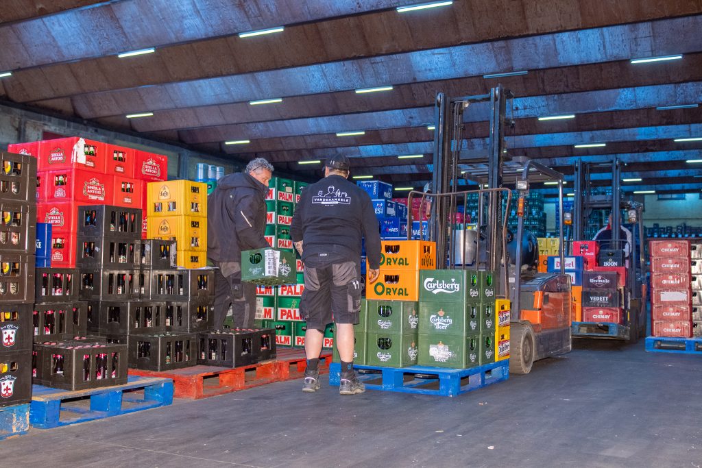 Werknemers bereiden leveringen voor groothandelklanten in het distributiecentrum van Dranken Vandenameele